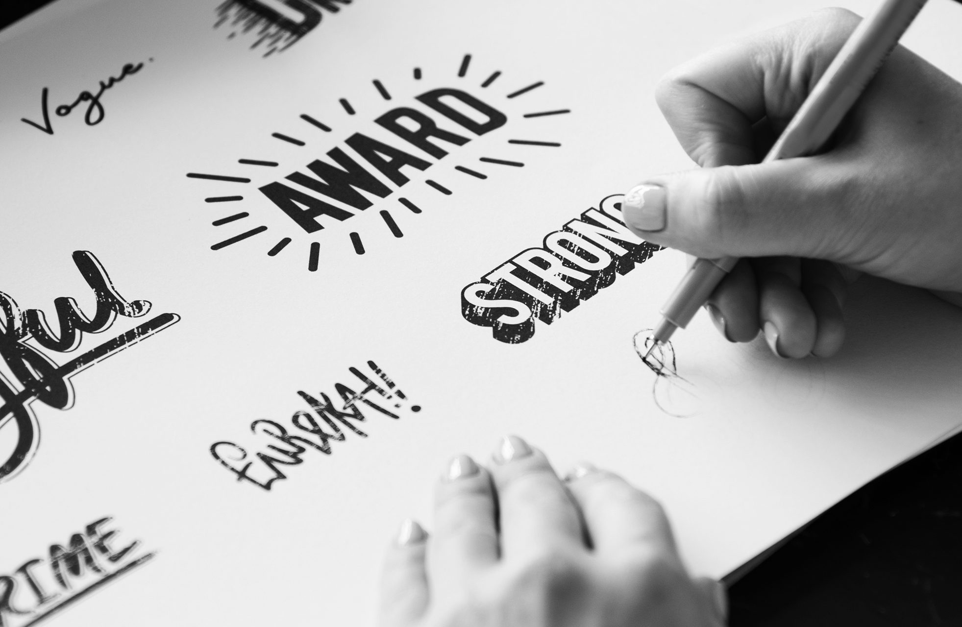 woman drawing word art and logo designs to create a strong brand for a business client