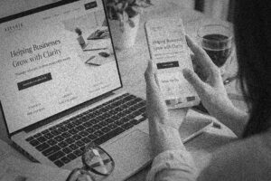 Woman reviewing a business website lead capture form on a computer and phone, demonstrating how strategic websites generate leads for businesses